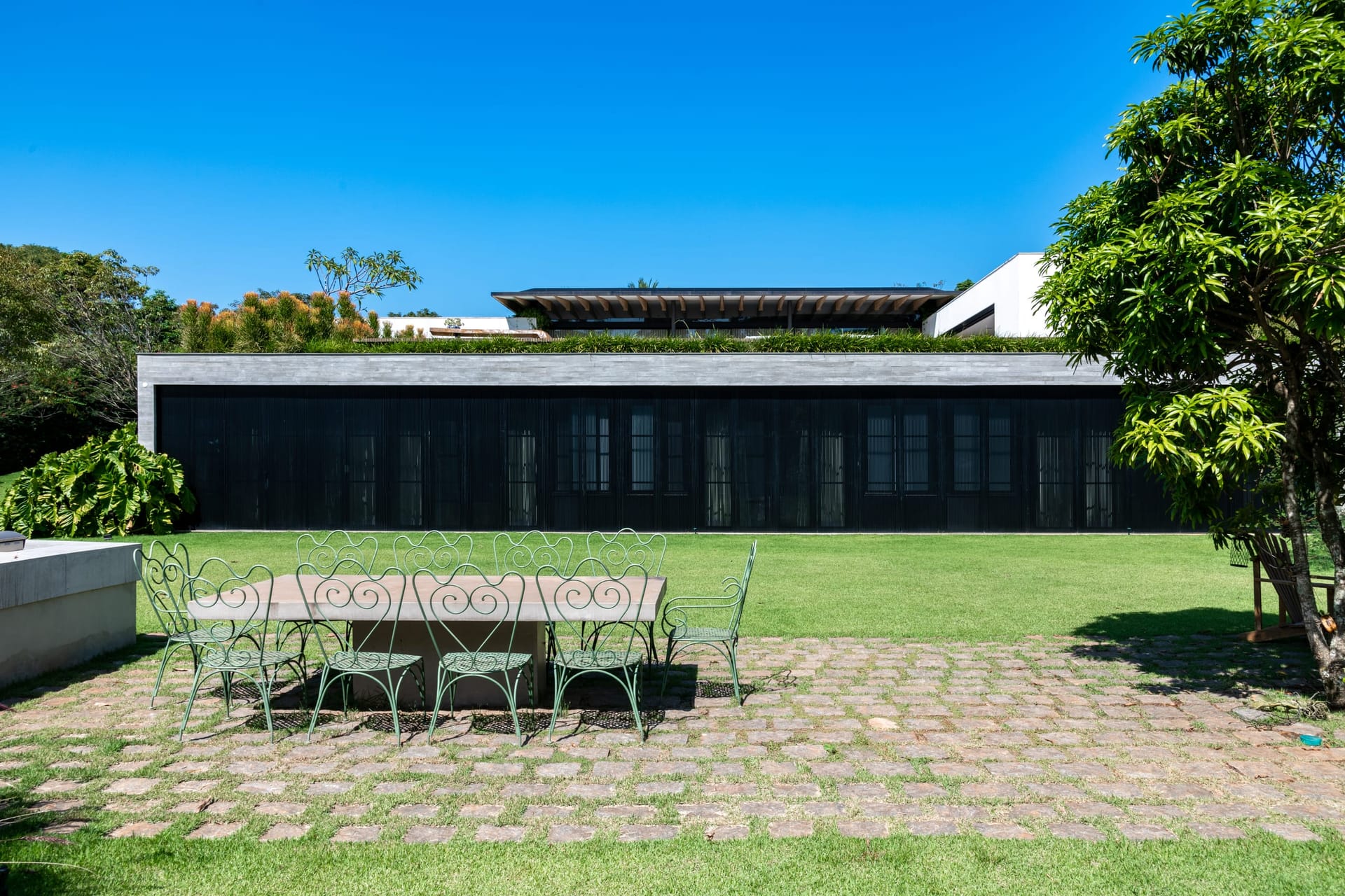 Fachada contemporânea de residência de alto padrão integrada ao jardim
